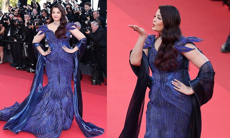 A woman in a stunning blue evening gown on the red carpet at a formal event.