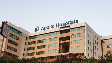Modern Apollo Hospitals building with clear signage and contemporary architecture in an urban setting.