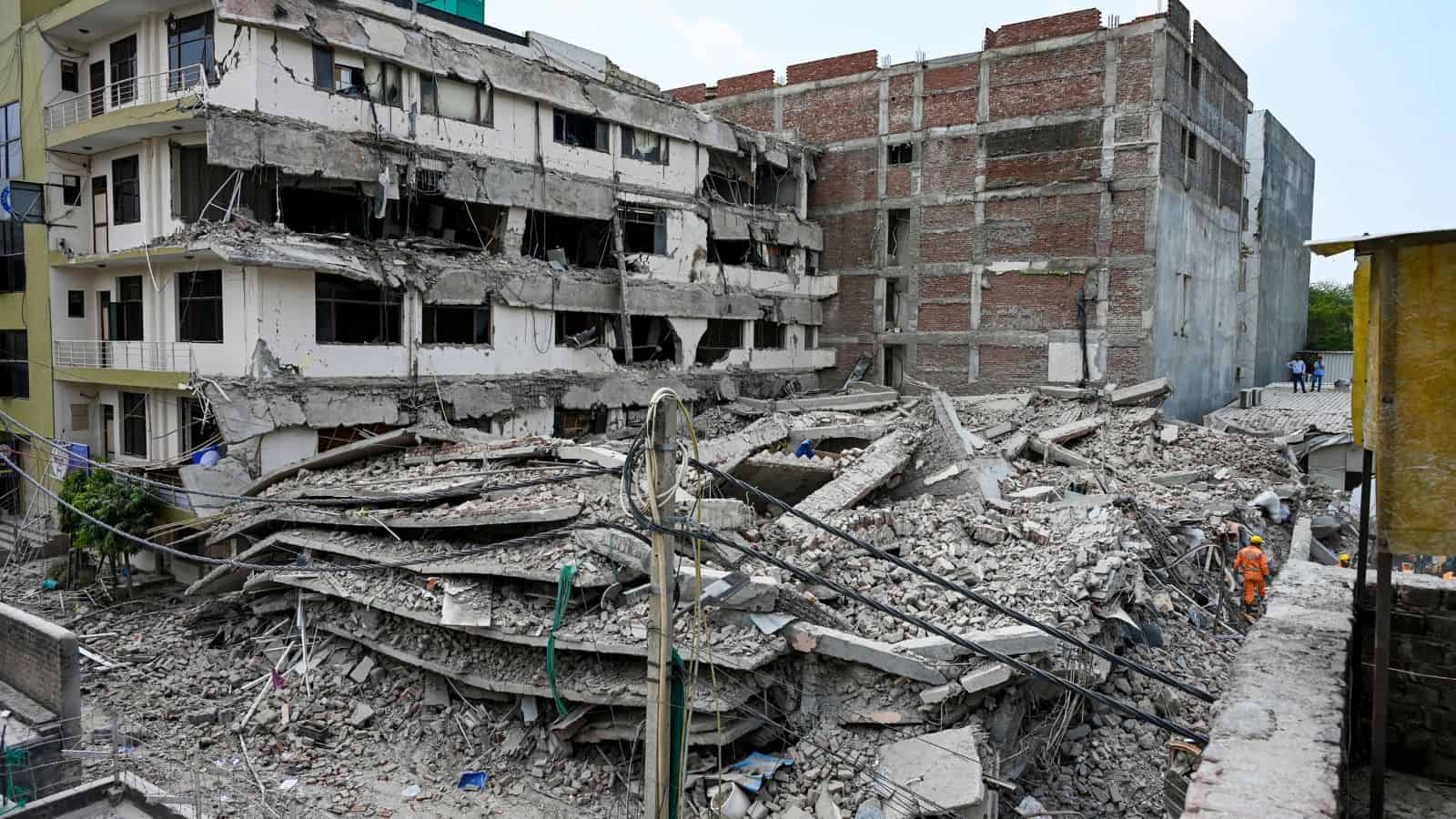 Building collapse aftermath in urban area, debris and damaged structures.