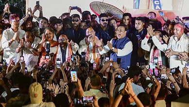 Politicians and officials at the Assam government swearing-in event on May 12, with crowd capturing the m.