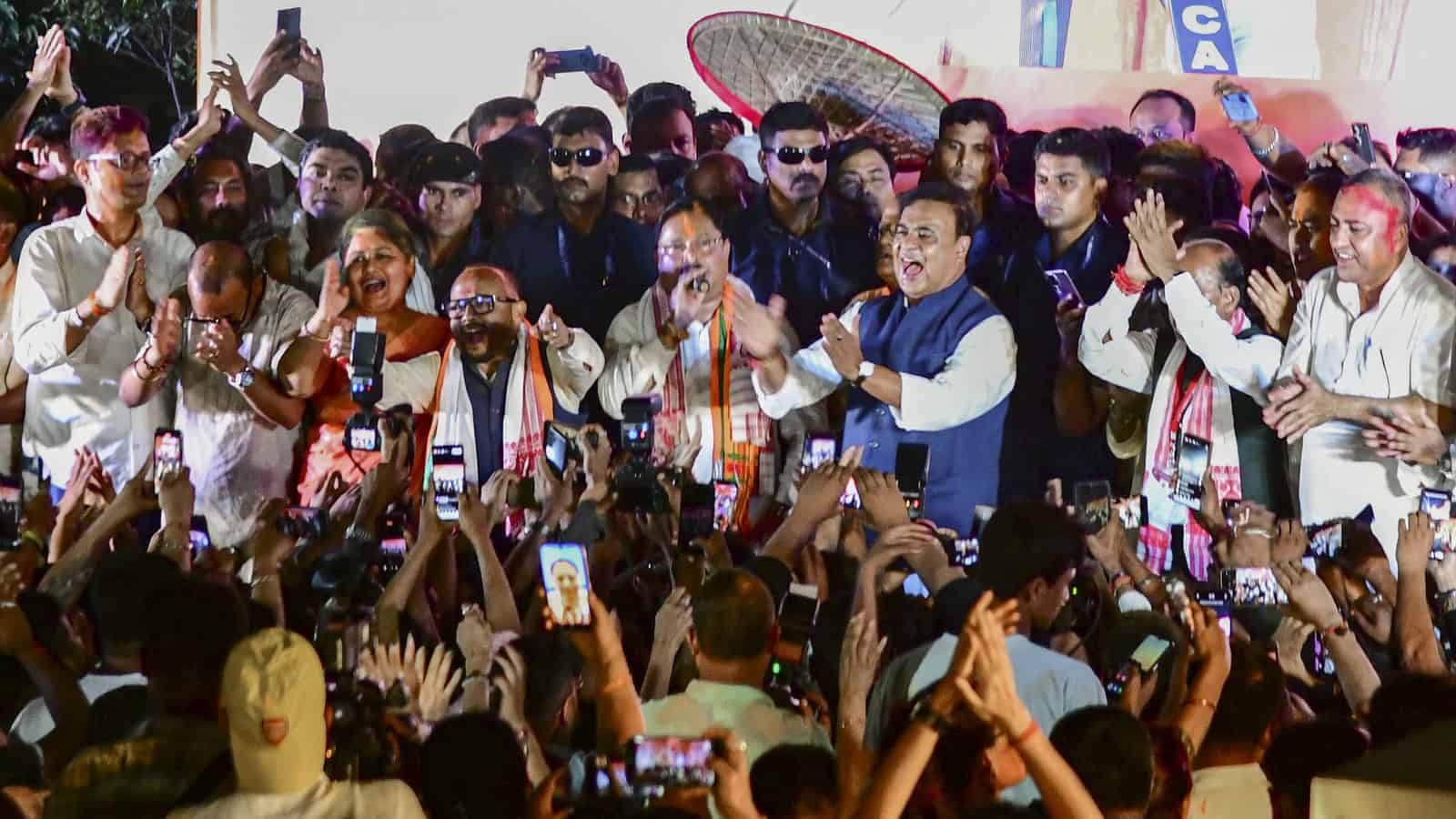 Politicians and officials at the Assam government swearing-in event on May 12, with crowd capturing the m.