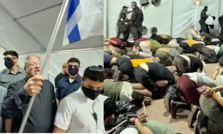 Israeli National Security Minister Itamar Ben-Gvir holds a flag as detained Gaza-bound flotilla participants kneel with their hands tied in Ashdod.