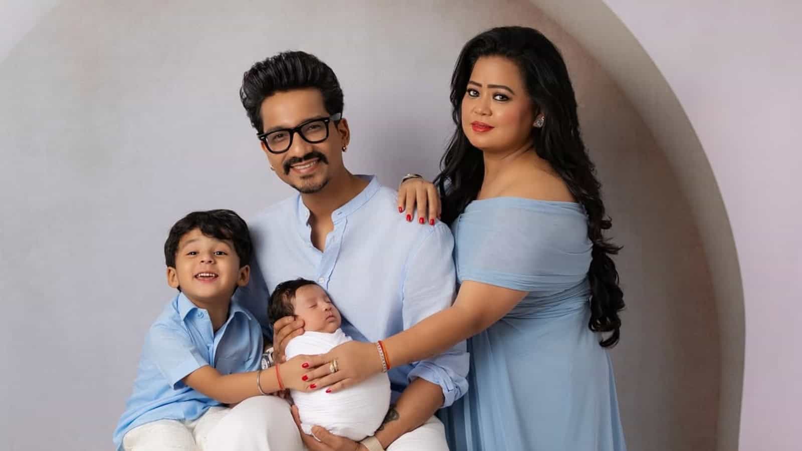 A happy family portrait of parents with two children, celebrating a joyful moment indoors.
