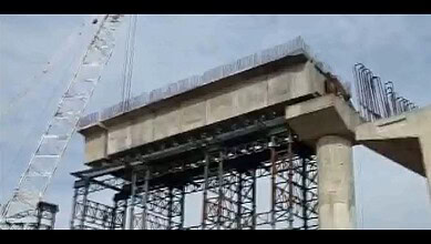 Bridge construction site with scaffolding and concrete structure under development.