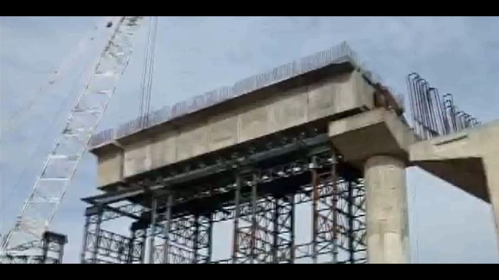 Bridge construction site with scaffolding and concrete structure under development.