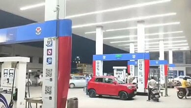 Fuel station with red car and fuel pumps in Hyderabad, where a man alleges fuel meter tampering after fil.