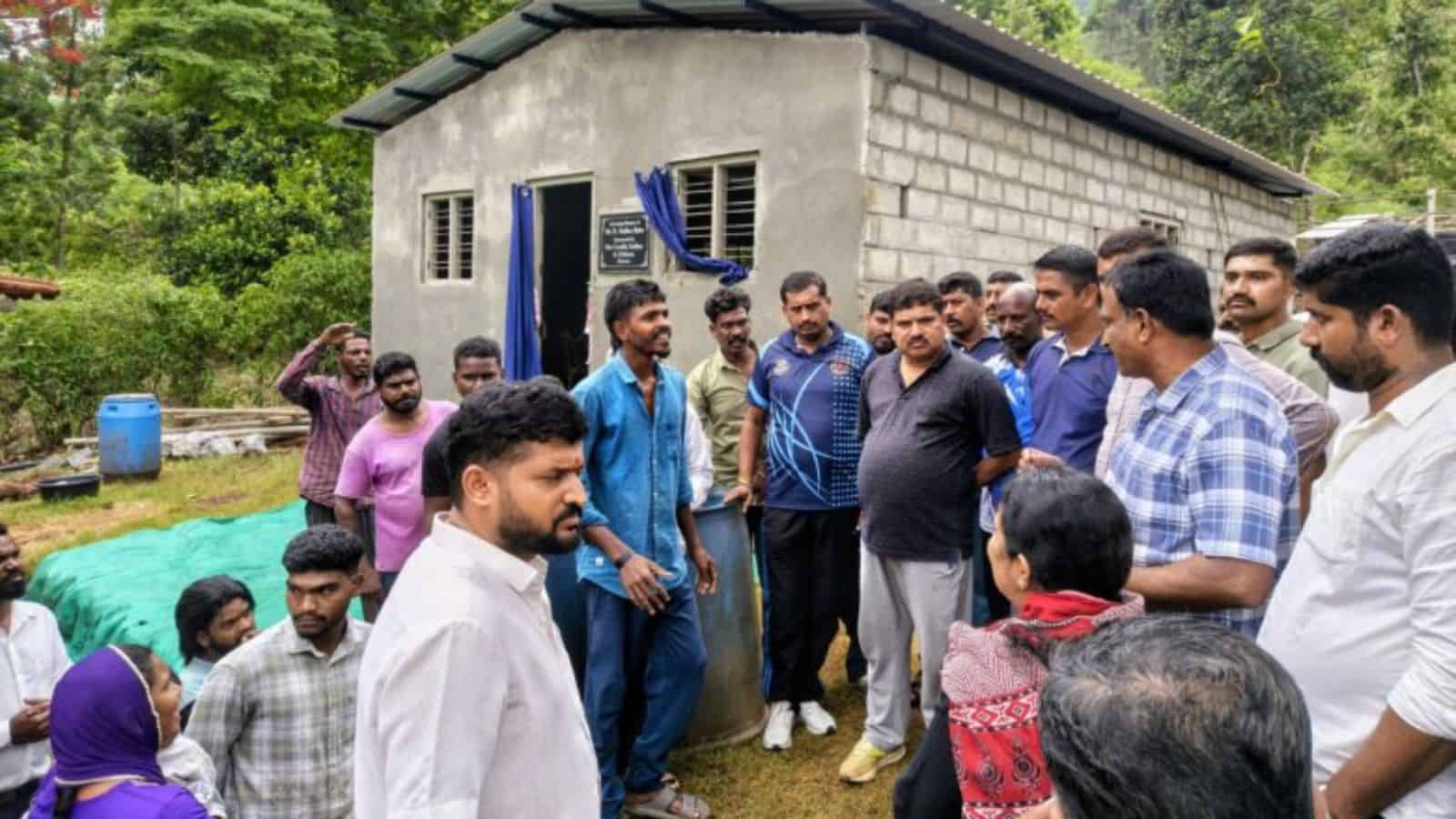 Community members and leaders engaged in discussion outside a modest rural home.