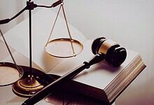 Image showing a gavel and scales of justice on a legal book, representing law, justice, and legal proceedings.
