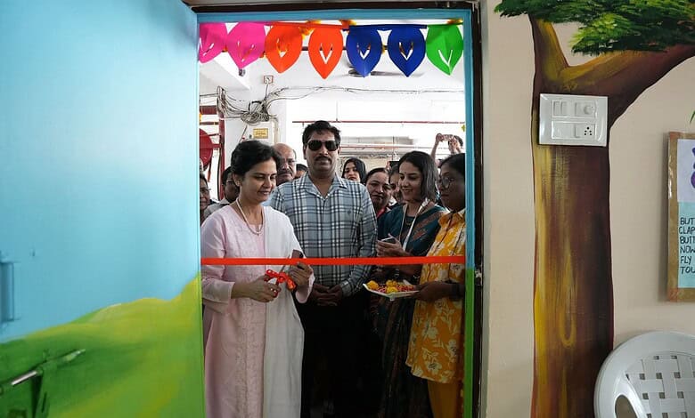 Image shows a woman cutting a ribbon during an event at the Siasat Daily office, with attendees and colourful decorations in the background.
