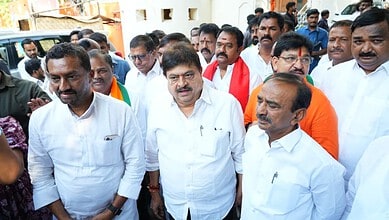 Political leaders gathering outdoors, engaging with supporters and media, during a public event or rally.