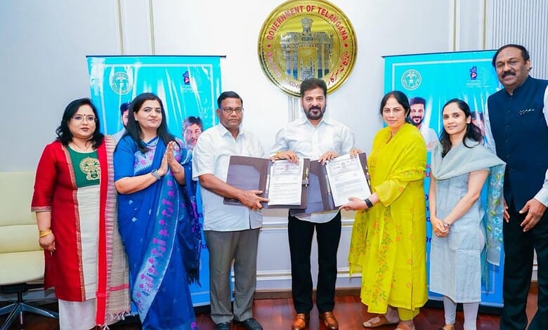 Government officials and women representatives participate in signing documents at the Telangana governme.