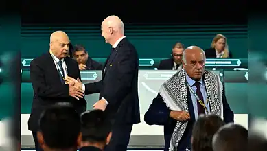 FIFA president Gianni Infantino shakes hands with Israeli FA chief Moshe Zuares as Palestinian FA head Jibril Rajoub walks off stage.
