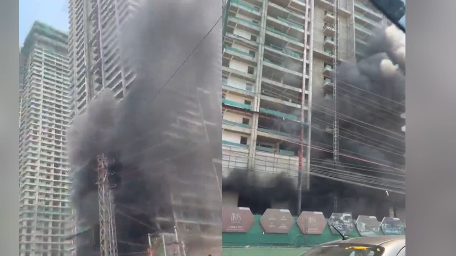 Fire incident at high-rise building with thick black smoke and flames, urban area with construction and v.