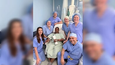 Recovered heart surgery patient poses with members of the visiting cardiac team in Nairobi.