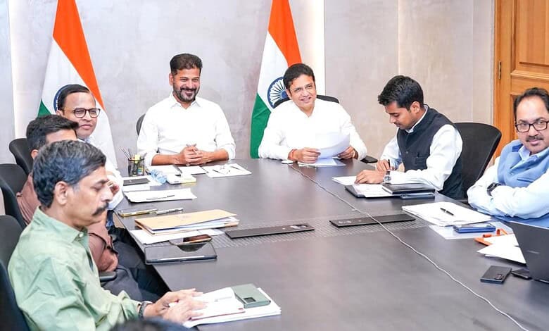 India government officials in a meeting with Indian flags in the background.