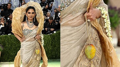 A woman in an elegant saree with floral accessories at the Met Gala, showcasing luxury fashion and style.