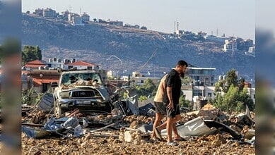 Explosion aftermath in urban area with debris and damaged vehicles.