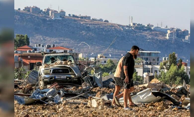 Explosion aftermath in urban area with debris and damaged vehicles.