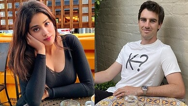 A young woman with long brown hair and a man with dark hair sitting at a table outdoors.