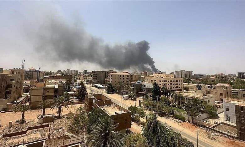 Explosion aftermath in Sudan city with smoke rising over buildings.