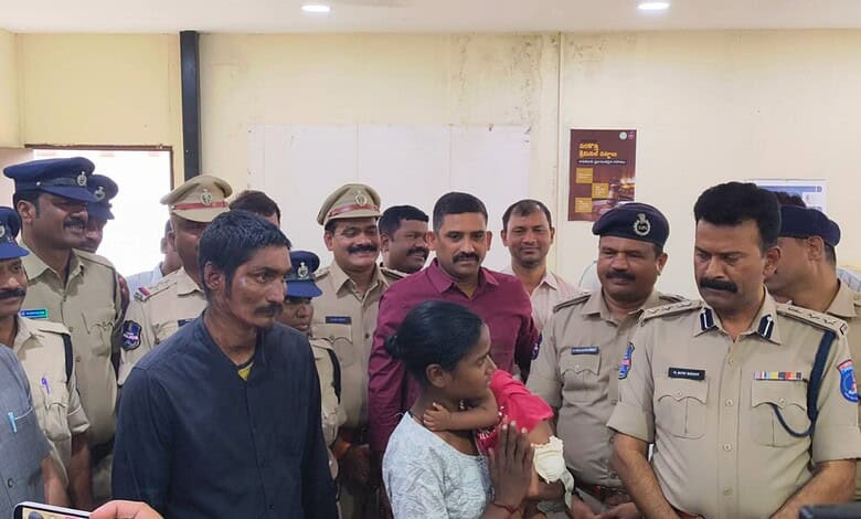A young girl is being comforted by police officers and officials after a successful rescue of a six-month.