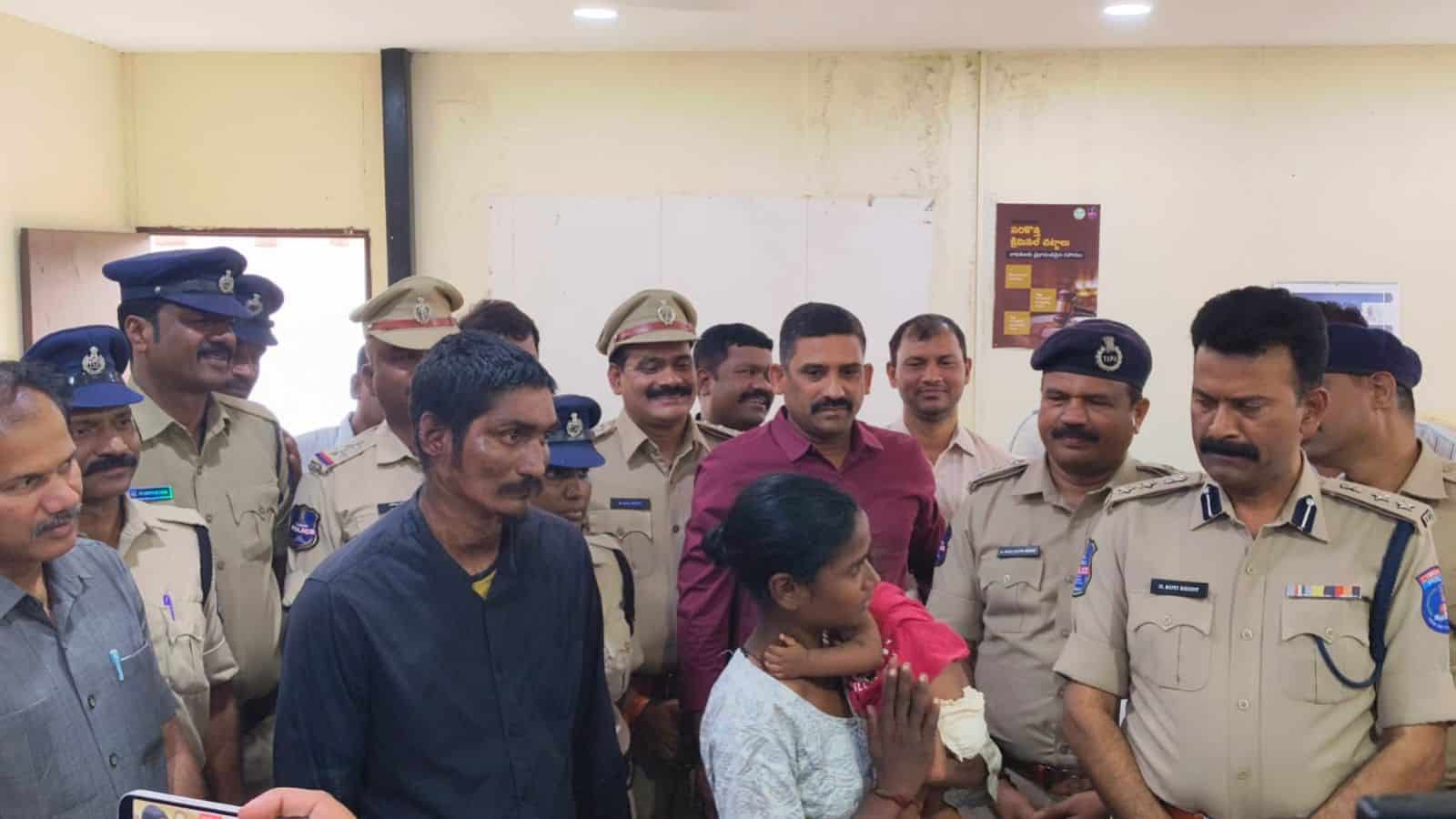 A young girl is being comforted by police officers and officials after a successful rescue of a six-month.