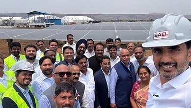 Innovative solar power plant visit with diverse team of professionals outdoors in bright sunlight.