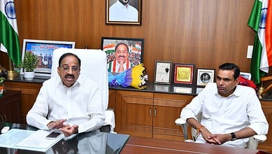 Prominent Indian politician speaking in a formal office setting with flags and framed photographs in the.