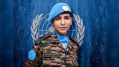 Young female UN peacekeeper in uniform with blue beret and UN insignia, standing confidently in front of.