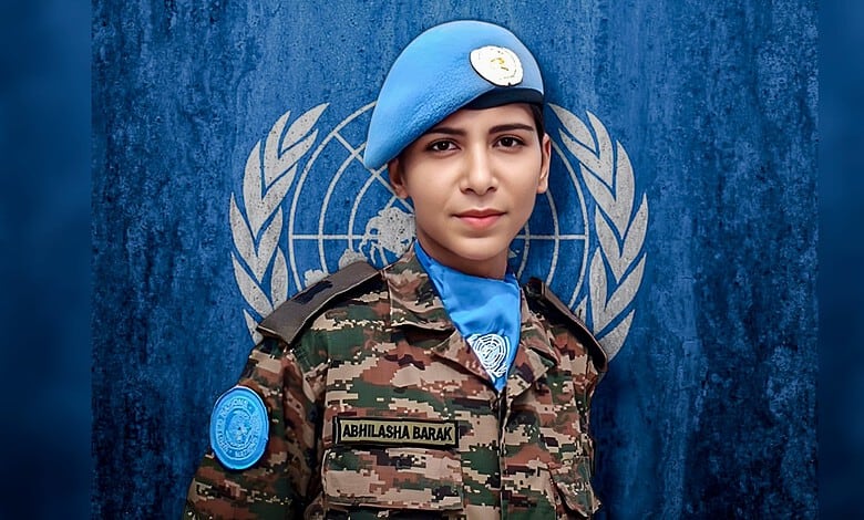 Young female UN peacekeeper in uniform with blue beret and UN insignia, standing confidently in front of.