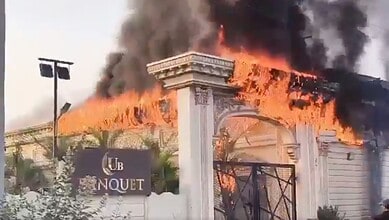 Fire engulfs Pista House Banquet Hall with thick black smoke and flames. Emergency services respond to co.