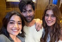 A smiling group of three friends taking a selfie indoors, showcasing friendship and happiness.