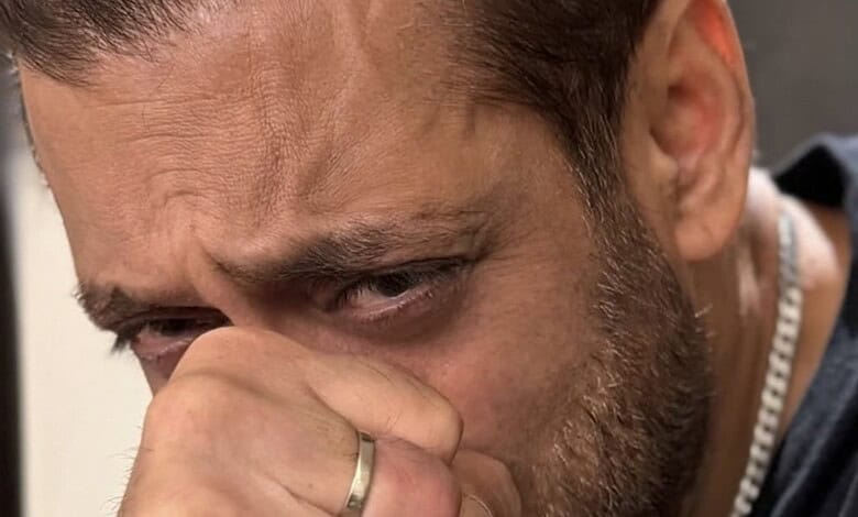 Salman Khan appears emotional, holding his face with a distressed expression during a public appearance.