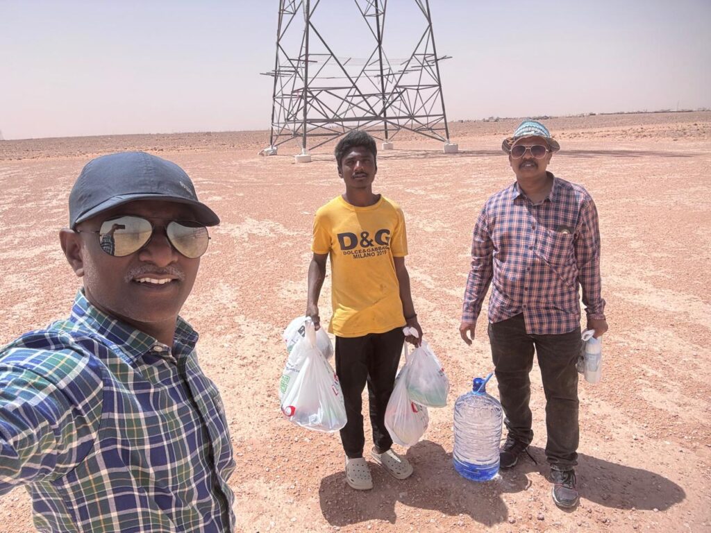 Members of the Saudi Arabia Telugu Association pose with Dasari Aravind in a desert area in Saudi Arabia after extending assistance.