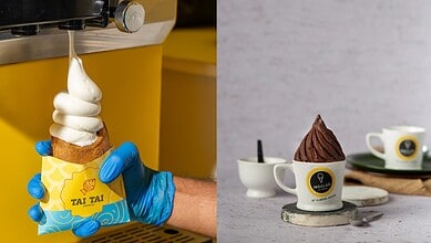 A person wearing blue gloves holding a soft serve ice cream cone with a yellow wrapper on a yellow ice cr.