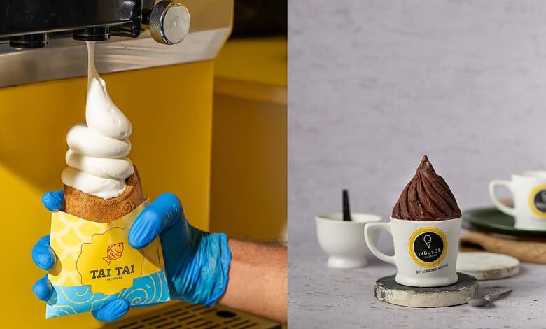 A person wearing blue gloves holding a soft serve ice cream cone with a yellow wrapper on a yellow ice cr.