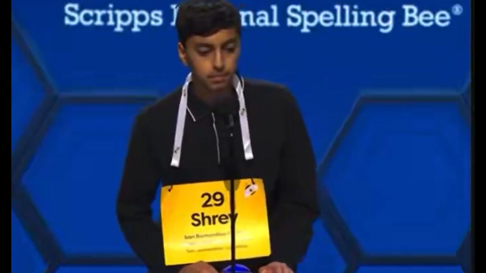Young boy competing in the Scripps National Spelling Bee with a focused expression.