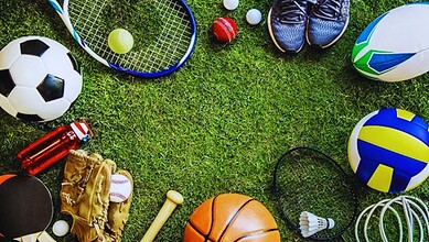 Sports equipment and gear on a grassy field for various sports activities.