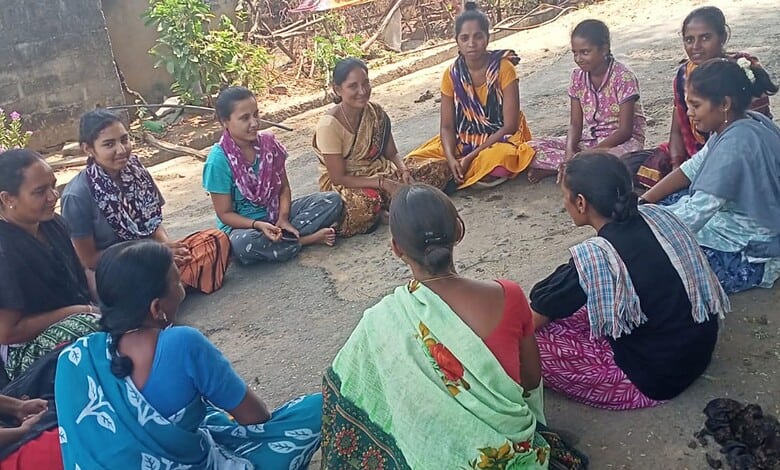 Group of adolescent girls and women participating in a community development session outdoors in Telangan.