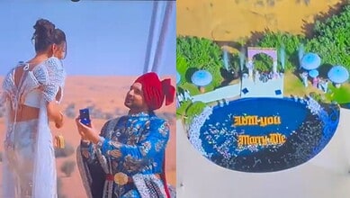 A woman taking a selfie with a woman in traditional attire in a desert landscape.