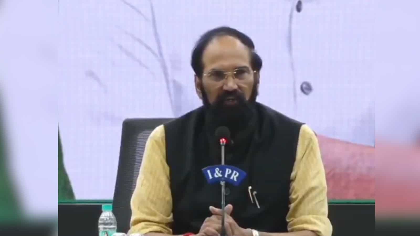 Indian Prime Minister speaking at a press conference with a microphone and backdrop.