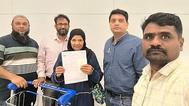 Community members holding documents and a shopping cart in an indoor setting, representing social activis.