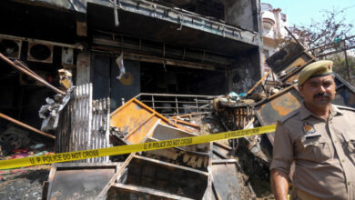 A police official at the site after a fire engulfed a three-story commercial building in a posh neighbourhood resulting in the deaths of 15 people