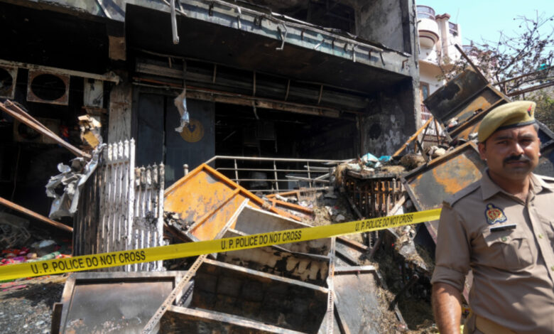 A police official at the site after a fire engulfed a three-story commercial building in a posh neighbourhood resulting in the deaths of 15 people