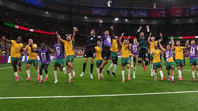Celebrating victory, football players jump and cheer on the field during a match at the stadium.