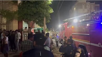 Crowd gathers outside bank after ATM catches fire due to short circuit in Hyderabad.