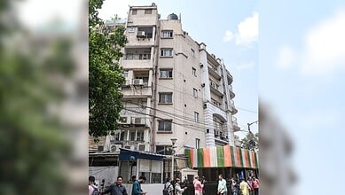 Multi-storey residential building with shops and street activity in an urban area, Hyderabad, India.
