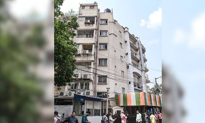 Multi-storey residential building with shops and street activity in an urban area, Hyderabad, India.