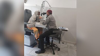Eye examination at Abid Ali Khan Eye Hospital with doctor and patient using slit lamp.