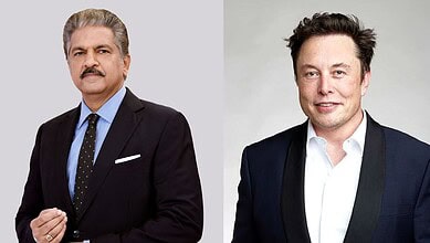 Two men in formal suits, one with grey hair and mustache, the other with dark hair, smiling.
